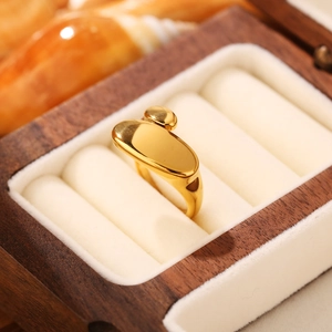 Dettaglio di un anello dorato minimalista posto in una custodia per gioielli in velluto