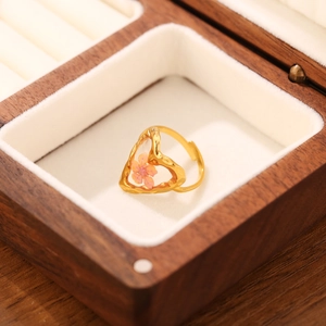 Dettaglio dell'anello aperto placcato oro 18K con un fiore rosa in una cornice a cuore