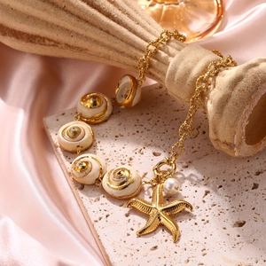 Meeresstil Muschelarmband mit goldenem Seestern und Perle auf rosa Seide Hintergrund