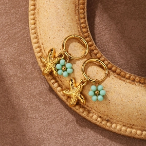 Detail of gold starfish and turquoise bead flower charms on these elegant hoop earrings