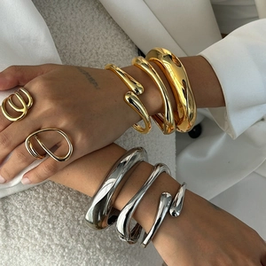 Bracciali chunky in acciaio inossidabile e anelli minimalisti indossati da modella