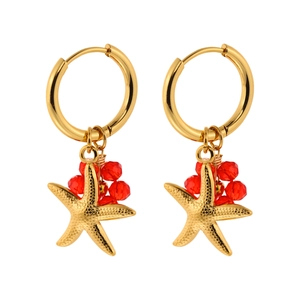 Elegant gold starfish drop earrings with red crystal beads on a white background