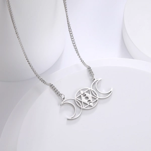 Macro shot of silver stainless steel triple moon goddess pendant with star engraving