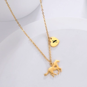 Dettaglio della collana in acciaio al titanio oro con cuore lettera N e ciondolo pony