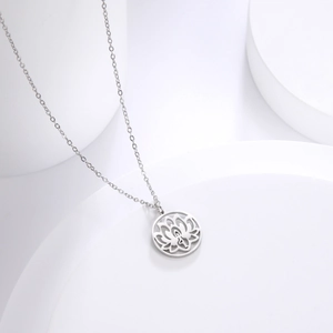 Detailopname van de minimalistische lotusbloem hanger aan een dunne ketting op wit decor