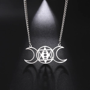Macro shot of 18k gold plated hexagram star and triple moon pendant on stainless necklace