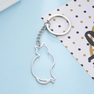 Detail of silver stainless steel cat silhouette keychain on decorative background