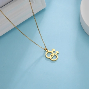 Gouden dubbele mannelijke symbool hanger aan fijne schakelketting op blauwe achtergrond