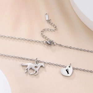 Detail of stainless steel necklace with heart letter F and pony horse pendants
