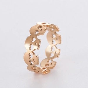 Detail of gold hollow heart skull pattern ring showing intricate cutout metal craftsmanship