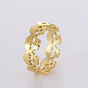 Detail of gold hollow skull ring featuring heart-shaped cutouts and polished finish