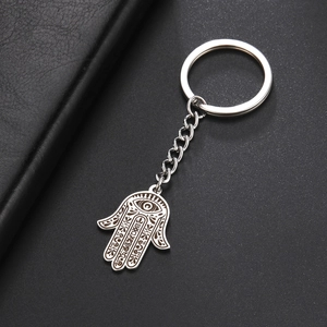 Detailed close-up of a silver stainless steel Hamsa hand keychain with an evil eye engraving