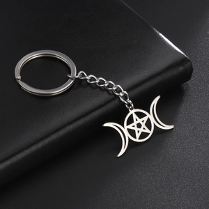 Detail shot of silver stainless steel triple moon and pentagram keychain on leather