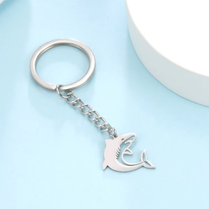 Polished stainless steel shark pendant keychain with flat ring on a modern blue background
