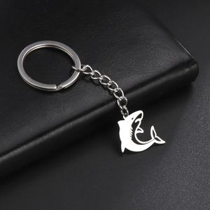 Macro shot of stainless steel shark keychain on black leather with a polished metal finish