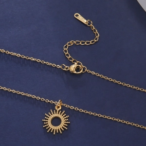Detailed macro view of the gold sun pendant necklace with adjustable chain and lobster clasp