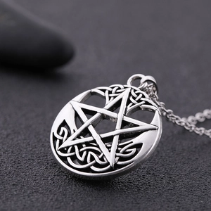 Macro close-up of vintage pentagram pendant with Celtic knot patterns in antique silver finish
