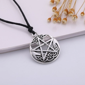Macro detail of vintage silver pentagram pendant with intricate Celtic knot patterns