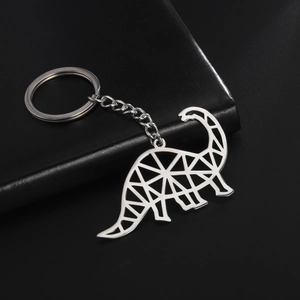 Macro shot of silver stainless steel brachiosaurus keychain on a black leather texture