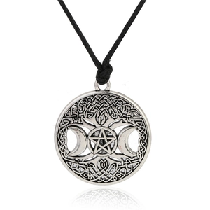 Macro shot of silver crescent moon and pentagram pendant with Celtic knot details