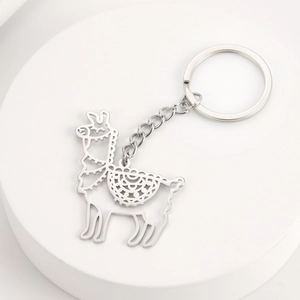 Detail of silver alpaca hollow-out keychain with intricate patterns on a round platform
