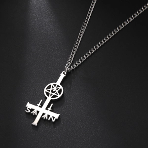 Macro shot of stainless steel inverted cross pendant with Satan engraving and pentagram