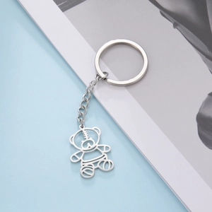 Detailed view of silver hollow bear pendant keychain with striped texture and metal chain