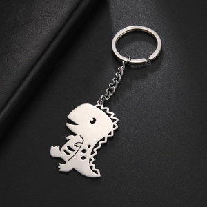 Detail shot of a silver cartoon dinosaur metal keychain with a polished steel chain and ring