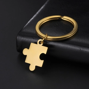Vue détaillée du pendentif puzzle doré poli miroir sur une surface en cuir noir de qualité
