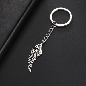 Detailed view of punk style stainless steel feather wing pendant on a metal keychain