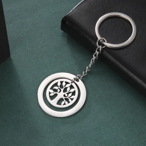 Polished stainless steel keychain featuring a hollow tree of life pendant on dark green background