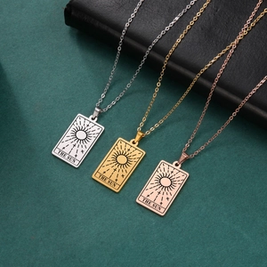 Detailed macro view of The Sun Tarot pendant in silver, gold, and rose gold stainless steel