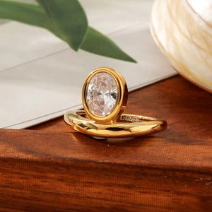 Anello vintage francese in titanio oro 18K con zircone ovale su fondo in legno naturale
