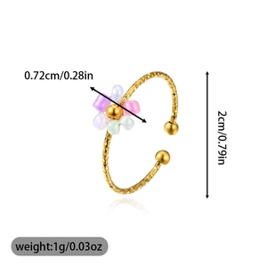 Detail view of adjustable gold ring with hammered texture and colorful beaded flower charm