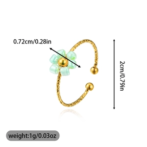 Detailed view of adjustable gold ring with light green beaded flower and dimensions
