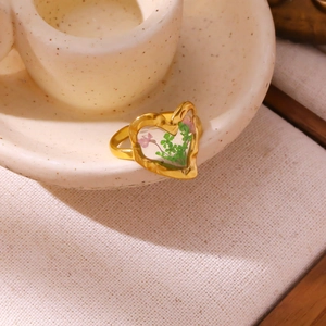 Detail of heart ring featuring real dried flowers embedded in a golden textured band
