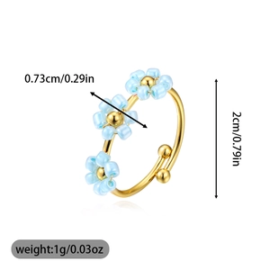 Detailed view of adjustable gold ring featuring three light blue beaded flowers and dimensions