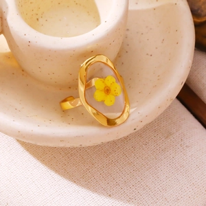 Minimalist gold titanium steel ring with yellow dried flower in a hollow oval frame