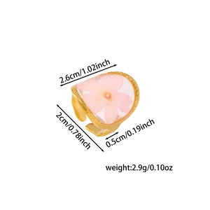 Detailed view of handmade pink dried flower resin ring with adjustable gold metal band