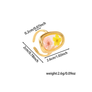 Detail view of gold open ring with pressed pink and yellow flowers in oval resin