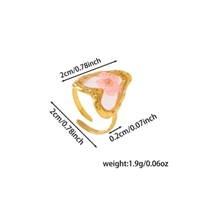 Detailed view of adjustable gold-finish ring with heart-shaped pink dried flower resin