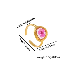 Detailed macro view of an adjustable gold ring featuring a pink dried flower inset