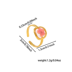 Detail of adjustable gold ring with pink dried flower in a clear resin square pendant