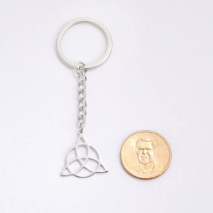 Porte-clés en acier titane avec pendentif Triquetra celtique et anneau de clé sur fond blanc