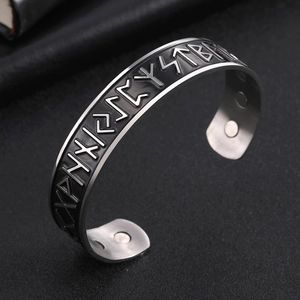 Macro detail of Nordic Viking runes on stainless steel cuff with health magnets