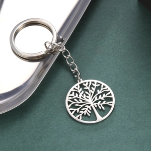 Silver stainless steel keychain with tree of life hollow pendant on a metallic tray