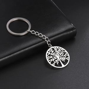 Detailed view of polished stainless steel tree of life pendant on a metallic keychain ring