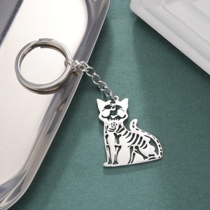 Detailed view of hollow skeleton cat keychain with star charm on dark textured background