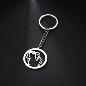 Detail of mother and child kiss engraving on polished stainless steel keychain pendant