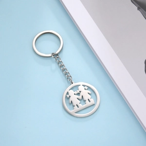 Detail of a stainless steel keychain with two girls holding hands cutout pendant